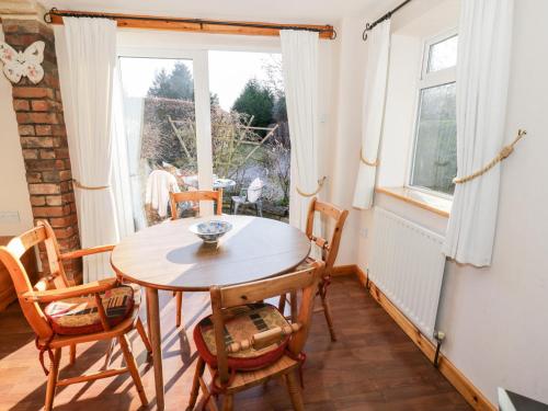 a dining room with a table and chairs and a window at The Orangery in Worcester