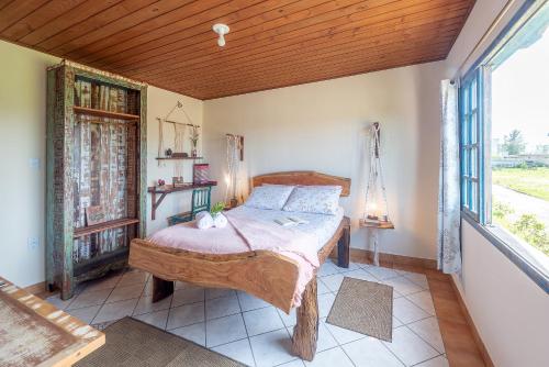 a bedroom with a bed and a large window at Apartamentos exclusivos e equipado com varanda ou terraço com Pôr do sol, cozinha privativa, Wi-Fi 600MBs, a 700m da praia de Itapirubá e 1km da BR-101 in Imbituba