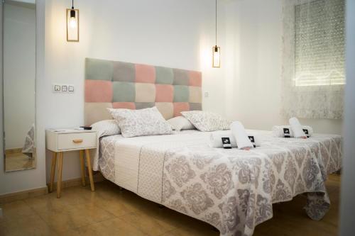 a bedroom with a bed with two alarm clocks on it at Hostal Goyesco Plaza in Plasencia