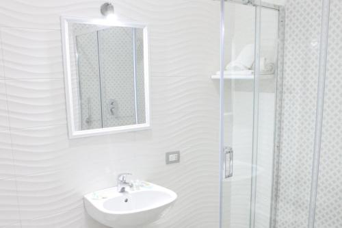 W łazience znajduje się umywalka i przeszklony prysznic. w obiekcie Albergo Casablanca w mieście Napoli