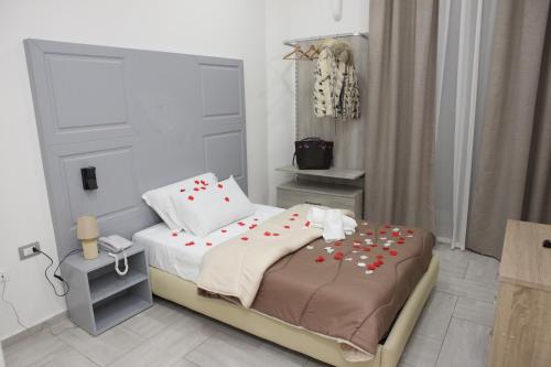een slaapkamer met een bed met rode bloemen erop bij Albergo Casablanca in Napels
