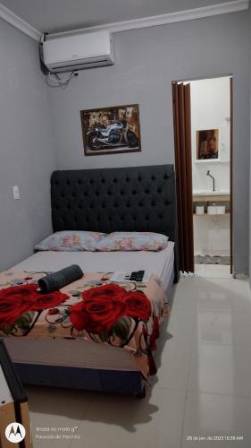 a bedroom with a bed with red roses on it at Pousada do Maninho in Penha