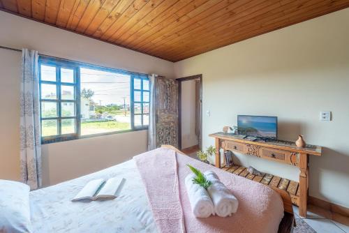 a bedroom with a bed and a desk with a laptop at Apartamentos exclusivos e equipado com varanda ou terraço com Pôr do sol, cozinha privativa, Wi-Fi 600MBs, a 700m da praia de Itapirubá e 1km da BR-101 in Imbituba