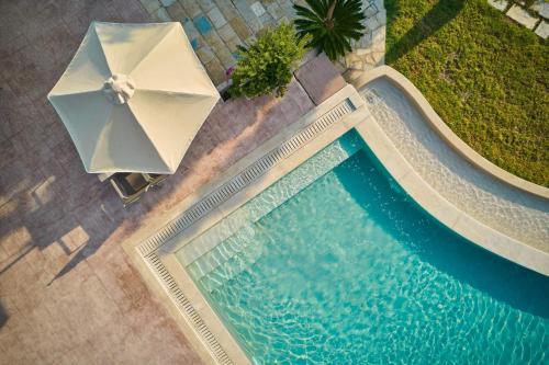 an overhead view of a swimming pool with an umbrella at Ionian Aura in Tsilivi