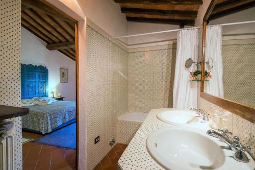 a bathroom with a sink and a bedroom with a bed at Villa Pozza di Volpaia in Radda in Chianti