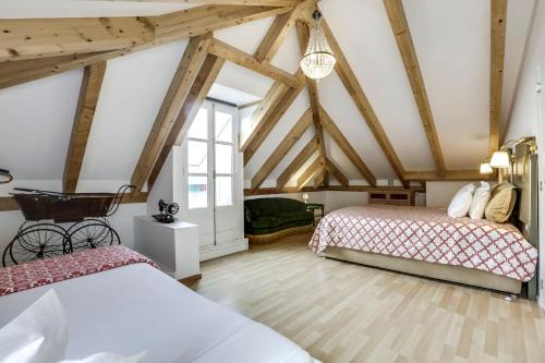 two beds in a attic room with wooden beams at LUXa Charm House by LovelyStay in Sintra