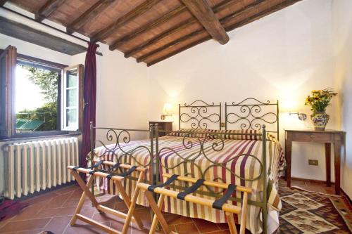 a bedroom with a bed with chairs in it at Villa Pozza di Volpaia in Radda in Chianti