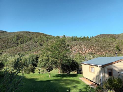 a house in a field with mountains in the background at Assegai Rest in Robertson
