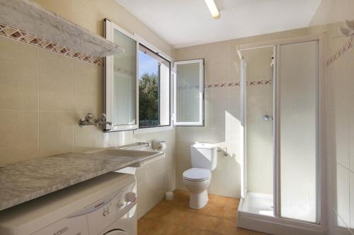 a bathroom with a toilet and a shower and a sink at Villa Toymi in Ciutadella