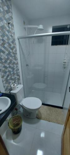 La salle de bains blanche est pourvue d'une douche et de toilettes. dans l'établissement apartamento para até 5 pessoas, à Vila Velha
