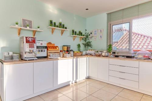 a large kitchen with white cabinets and a window at Ionian Aura in Tsilivi