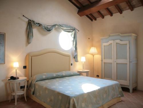 a bedroom with a bed and two tables and two lamps at Canonica di Corteranzo in Murisengo