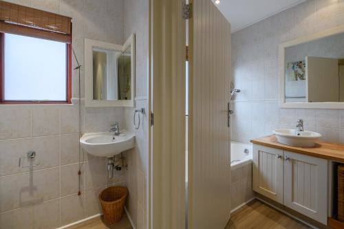 uma casa de banho com 2 lavatórios, um chuveiro e um espelho. em San Lameer Villa 14110 - 5 Bedroom Luxury - 10 pax - San Lameer Rental Agency em Southbroom