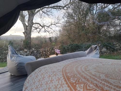 a bed and a couch sitting on a deck at Luxury Glamping Dome with views of the Burren in Boston