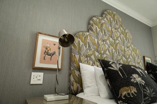 a bedroom with a bed with a large headboard at Cape Village Lodge in Durbanville