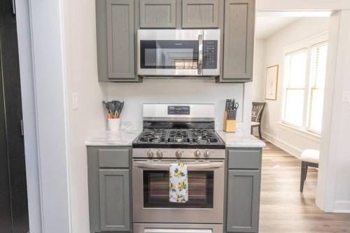 a kitchen with a stove and a microwave at Downtown Retreat, Hot Tub, Firepit, Grill in Michigan City