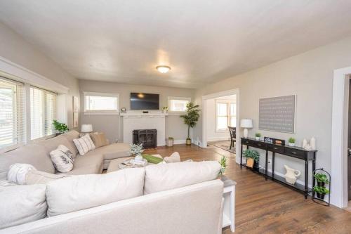 a living room with a white couch and a fireplace at Downtown Retreat, Hot Tub, Firepit, Grill in Michigan City