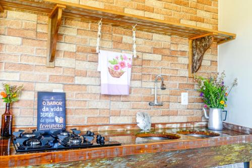a kitchen with two sinks and a brick wall at Apartamentos exclusivos e equipado com varanda ou terraço com Pôr do sol, cozinha privativa, Wi-Fi 600MBs, a 700m da praia de Itapirubá e 1km da BR-101 in Imbituba