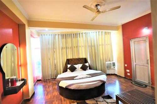 a bedroom with a bed in a room with red walls at Mahadev Hotel and Resorts in Katra