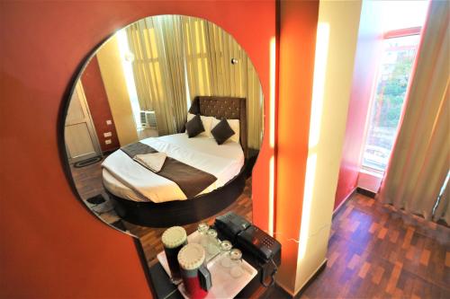 a bedroom with a bed in front of a mirror at Mahadev Hotel and Resorts in Katra