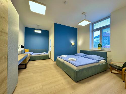 sypialnia z 2 łóżkami i niebieską ścianą w obiekcie DOBRÉ MÍSTO w Karniowie