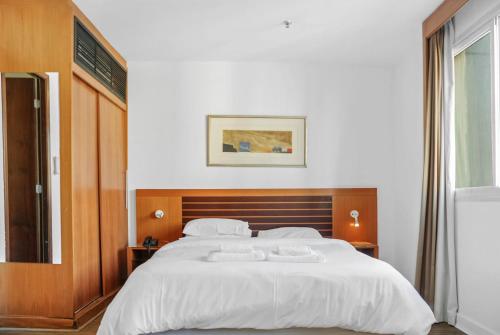 1 dormitorio con 1 cama blanca grande y 2 toallas en Hotel deslumbrante na Avenida Paulista, en São Paulo