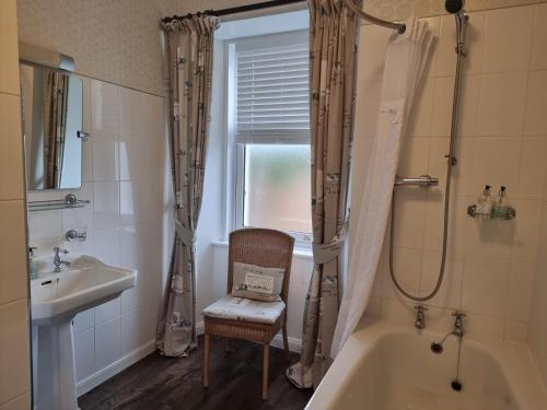 ein Bad mit einer Badewanne, einem Waschbecken und einer Dusche in der Unterkunft Langass Lodge in Carinish