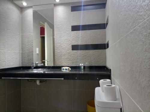 y baño con lavabo, aseo y espejo. en Edificio Los andes - n11 en Villa Carlos Paz