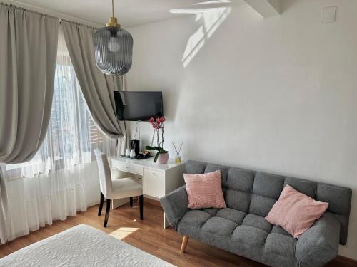 un soggiorno con divano e scrivania di Villa Greta Hotel Rooms & Suites a Taormina