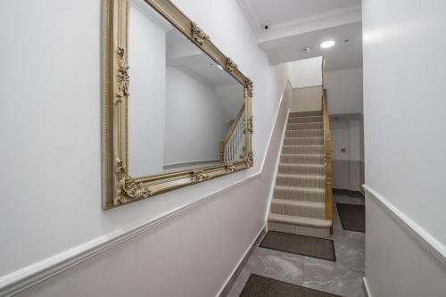 een spiegel aan een muur naast een trap bij Marylebone Village Apartments in Londen