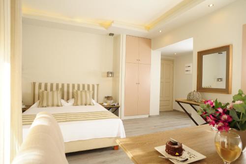 a bedroom with a bed and a table with a vase of flowers at Pepi Boutique Hotel (Adults Only) in Rethymno Town