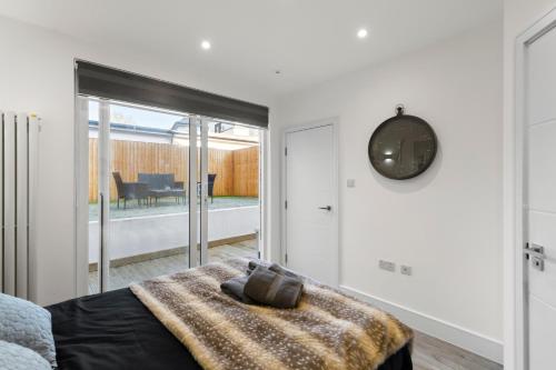 a bedroom with a bed and a clock on the wall at Star London Vivian Avenue 3-Bed Oasis with Garden in The Hyde