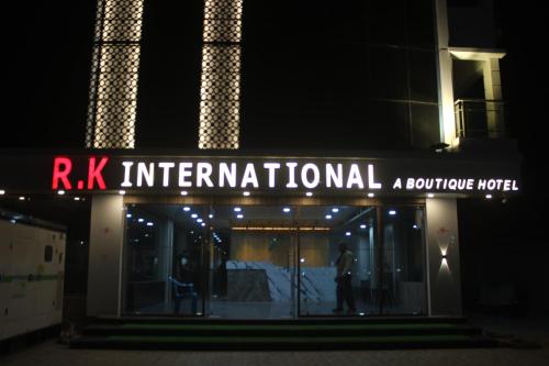 ディガにあるHotel RK Internationalの夜の建物の前に立つ男