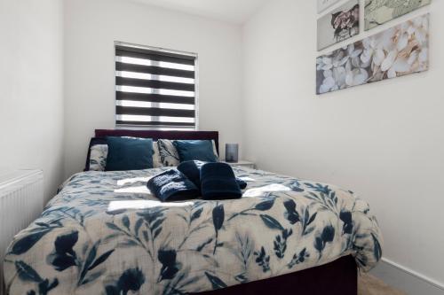 a bedroom with a bed with a blue and white comforter at Star London Vivian Avenue 2-Bed Haven in The Hyde