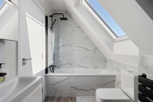 een badkamer met een wit bad en een wastafel bij Flat 5 - Star London Vivian Lane 2-Bed Residence in The Hyde