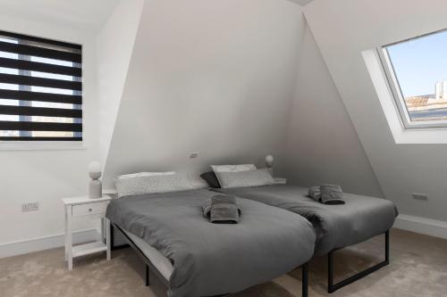 two beds in a white room with a window at Flat 5 - Star London Vivian Lane 2-Bed Residence in The Hyde