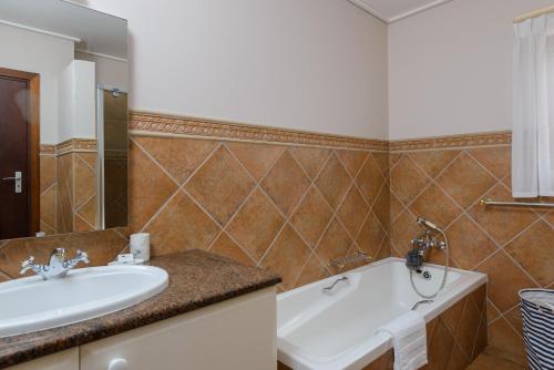 a bathroom with a sink and a mirror and a tub at San Lameer Villa 14101 - 3 Bedroom Classic 6 pax - San Lameer Rental Agency in Southbroom