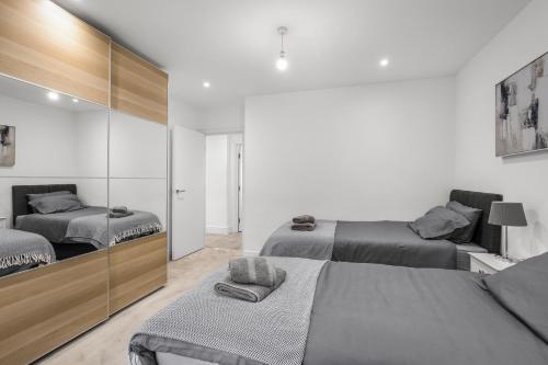 a bedroom with two beds and a mirrored wall at Star London Vivian Avenue 2- Bed Abode in The Hyde