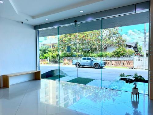 a living room with glass walls and a car outside at Sun Inn in Songkhla