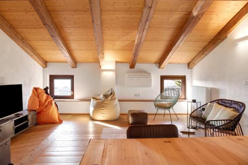 a living room with wooden ceilings and a table and chairs at Vicolo 10 in Asti
