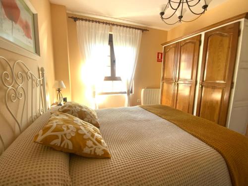 Un dormitorio con una cama con dos almohadas encima. en LA TUDANCA DE CASASOLA Sin sorpresas, oficial, Comillas 5 min, en Ruiloba