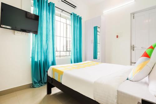 1 dormitorio con 1 cama y TV de pantalla plana en OYO Home KC Arcade en Kochi