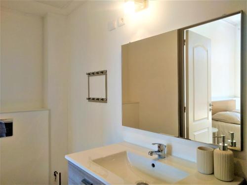 La salle de bains est pourvue d'un lavabo et d'un grand miroir. dans l'établissement Sublime et spacieux logement - Beau quartier Le Cours Foucault - 4 couchages - Places de stationnements gratuites - Balcon et vue sur Parc arboré - 5 min à pied de l'hypercentre Montauban, à Montauban