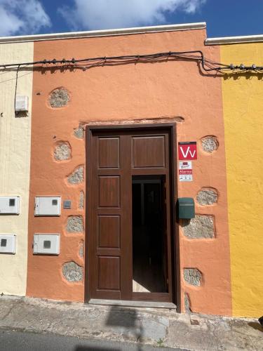 un bâtiment avec une porte marron sur son côté dans l'établissement Casa Mojo, à Agüimes