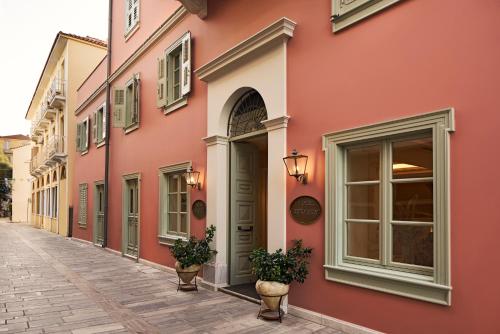 a street in an old town with pink buildings at Hotel Ippoliti in Nafplio