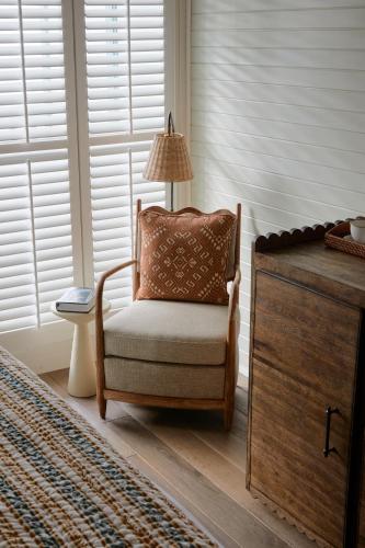 a chair in a room with a lamp and a dresser at Soho Beach House Canouan in Canouan