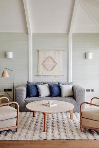 a living room with a couch and a coffee table at Soho Beach House Canouan in Canouan