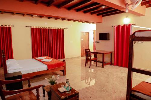 a bedroom with two beds and a table and a desk at Kudajadri Heritage Homestay in Kaniyāmbetta