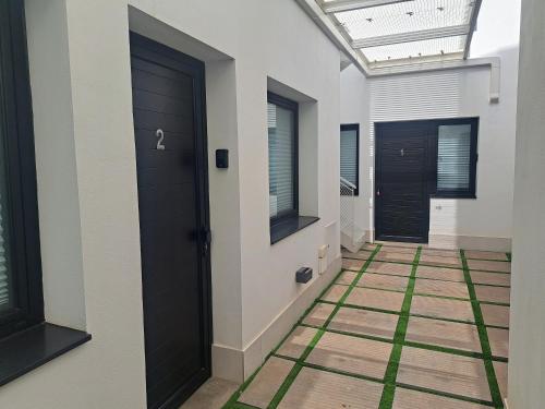 a hallway with black doors and a green floor at Calma Suites Tejeda in Tejeda