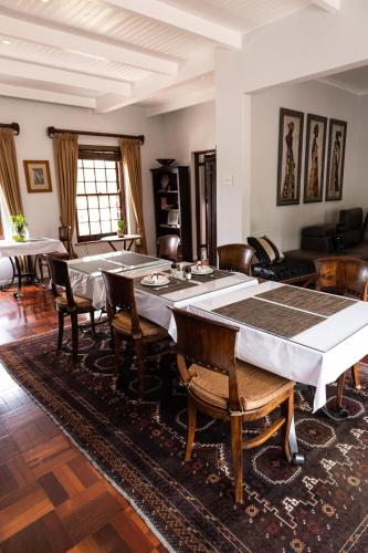 a living room with a large table and chairs at Cape Village Lodge in Durbanville